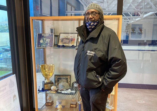 Gary W. Johnson, Athletic Director at Wallenberg High School stands in front of trophy case at school