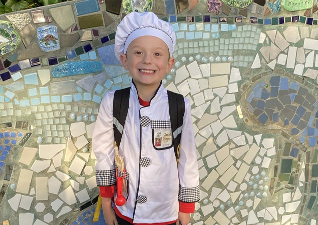 James, a third grader, wears a chef's hat and coat
