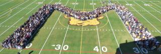 Mission HS students on a football field forming an "M"