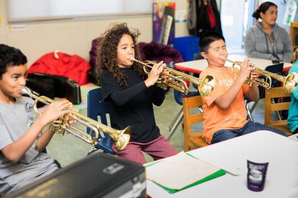Elementary school students playing trumpets