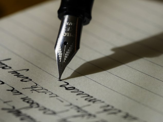A pen writes on a paper. 