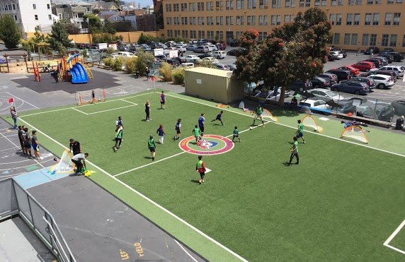 People playing soccer in a shared schoolyard
