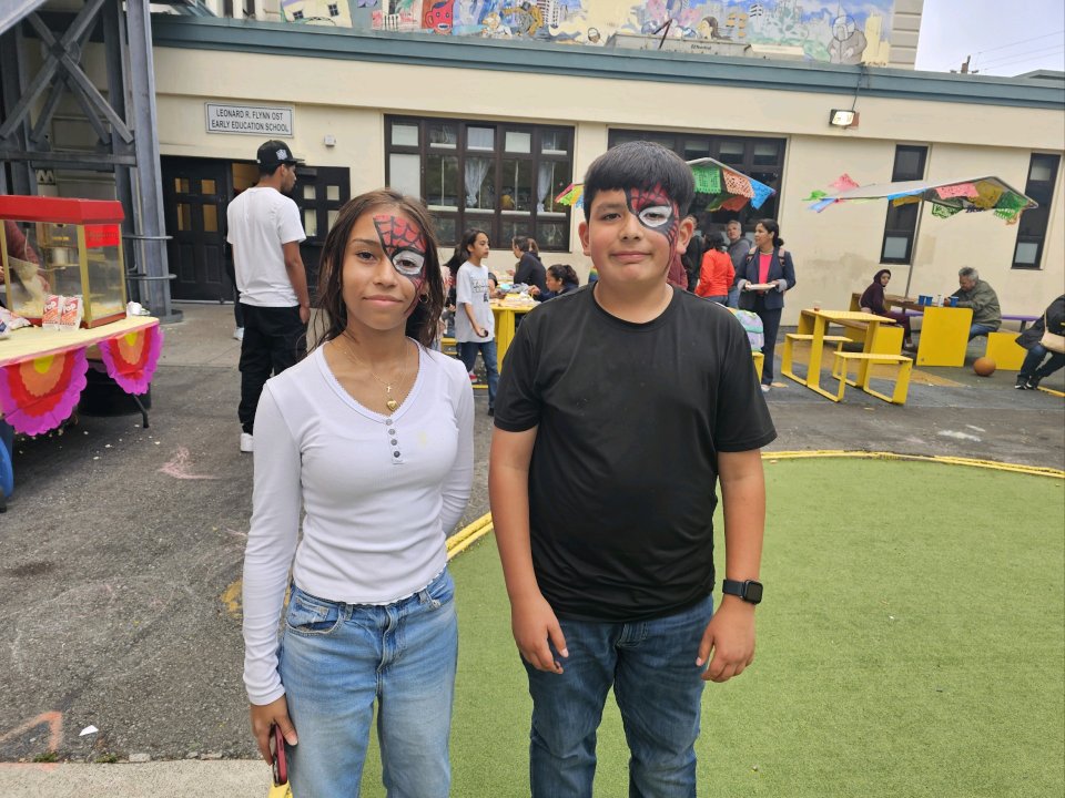 2 students with their face painted smiling for camera