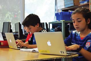 Elementary school students working on laptops