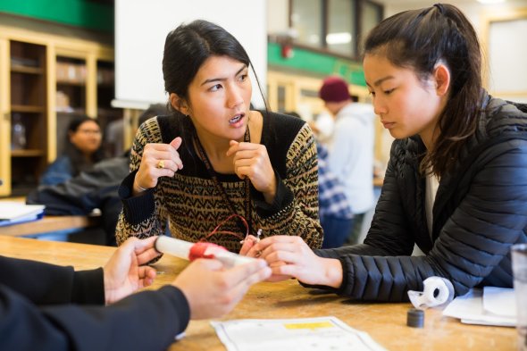 Teacher instructing student in science project