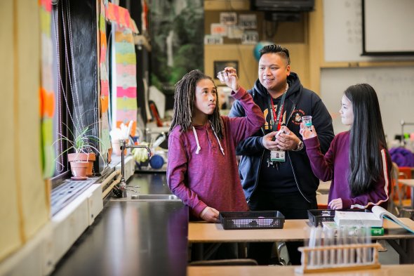 Two students and staff person doing science