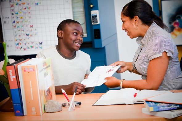 Teacher handing student an A+ paper