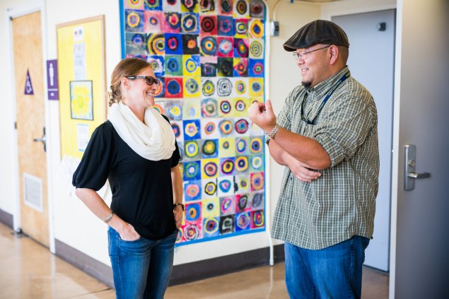 Two staff persons talking near an office