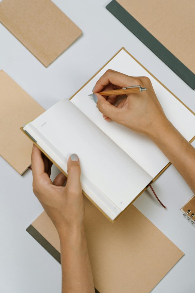 Hand taking notes on Notebook